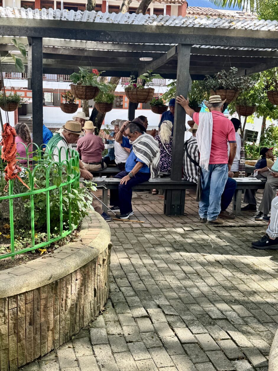 Am Hauptplatz treffen sich Alle, viele spielen Karten und Domino